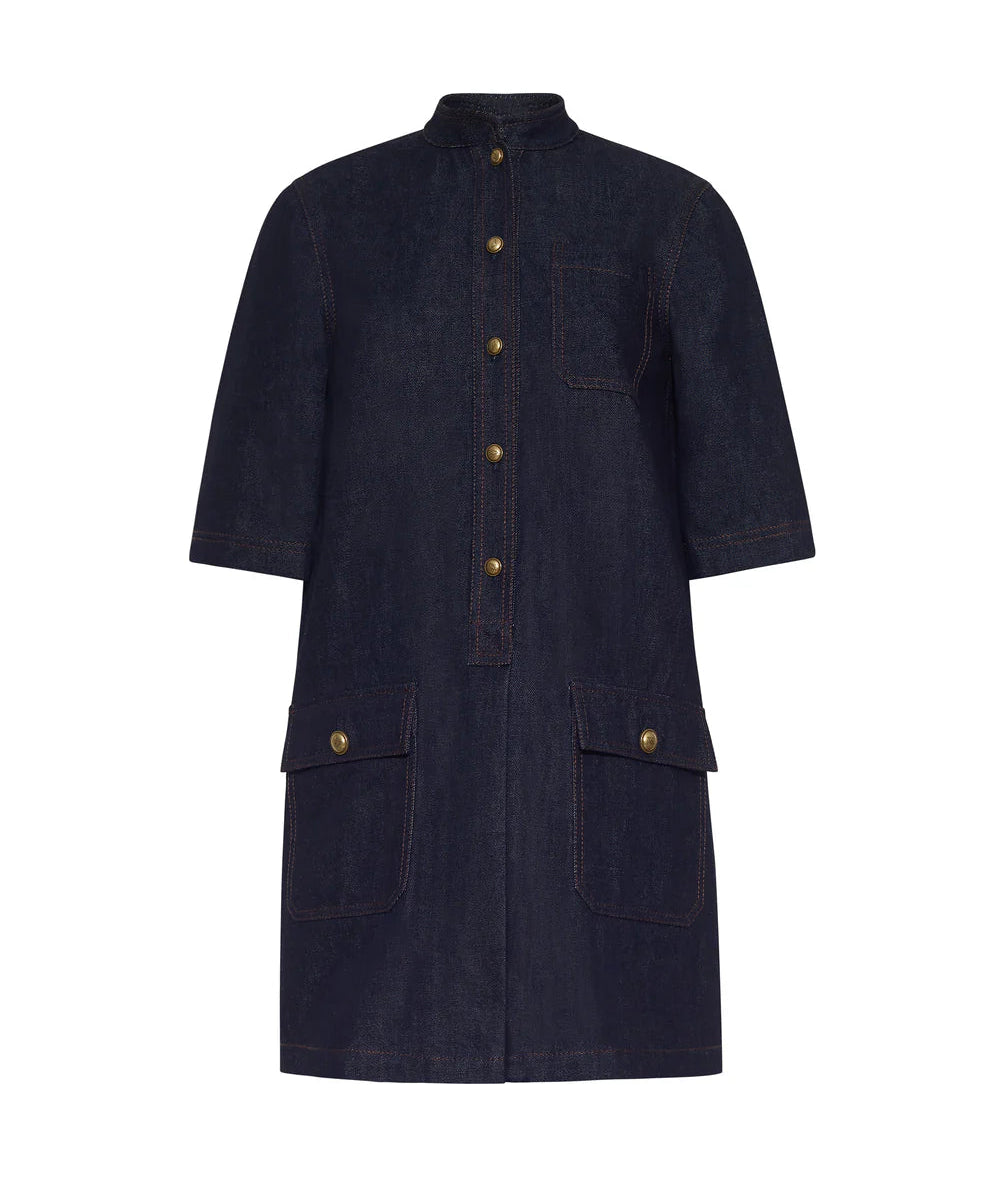 The Lauder Dress by Adam Lippes is a dark Japanese indigo denim, knee-length dress featuring short sleeves, topstitching accents, front buttons, a chest pocket, and two large front flap pockets with antique matte gold closures.