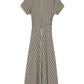 The Sadie Stripe Dress by Adam Lippes is a beige short-sleeve A-line Italian cotton dress with vertical and diagonal black stripes, a matching waist tie, and is displayed from the back.