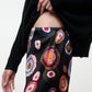 Person wearing Staud’s Stroll Silk Pant, paired with a black sweater, showing part of their midriff against a plain background—the look captures an effortless drape that adds movement and ease to the ensemble.