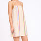 A woman models the Staud Laura Linen Mini Dress—sleeveless, beige, with summer stripe accents—against a plain white background.