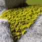 Close-up of Jellycat Rockleton’s plush surface, featuring a patch of bright yellow-green textured fur surrounded by soft gray fur.