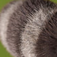Close-up of a Jellycat Trixiwoo Raccoon plush’s furry, striped tail with dark and light bands, set against a green background.