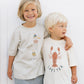 Two children stand side by side against a white wall, both wearing Rylee & Cru Baby Boys' & Boys' Relaxed Tee—crafted from soft cotton jersey and available in baby sizes.