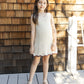 A young girl wears the Rylee & Cru Girls' Crochet Tank Mini Dress, standing on a wooden deck before a shingled wall, with rope and sunlight in the background.