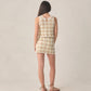 A woman faces away, wearing the Rylee & Cru Teen Girls' Crochet Tank Set in citron daisy check geometric pattern with brown sandals, posed against a neutral backdrop.