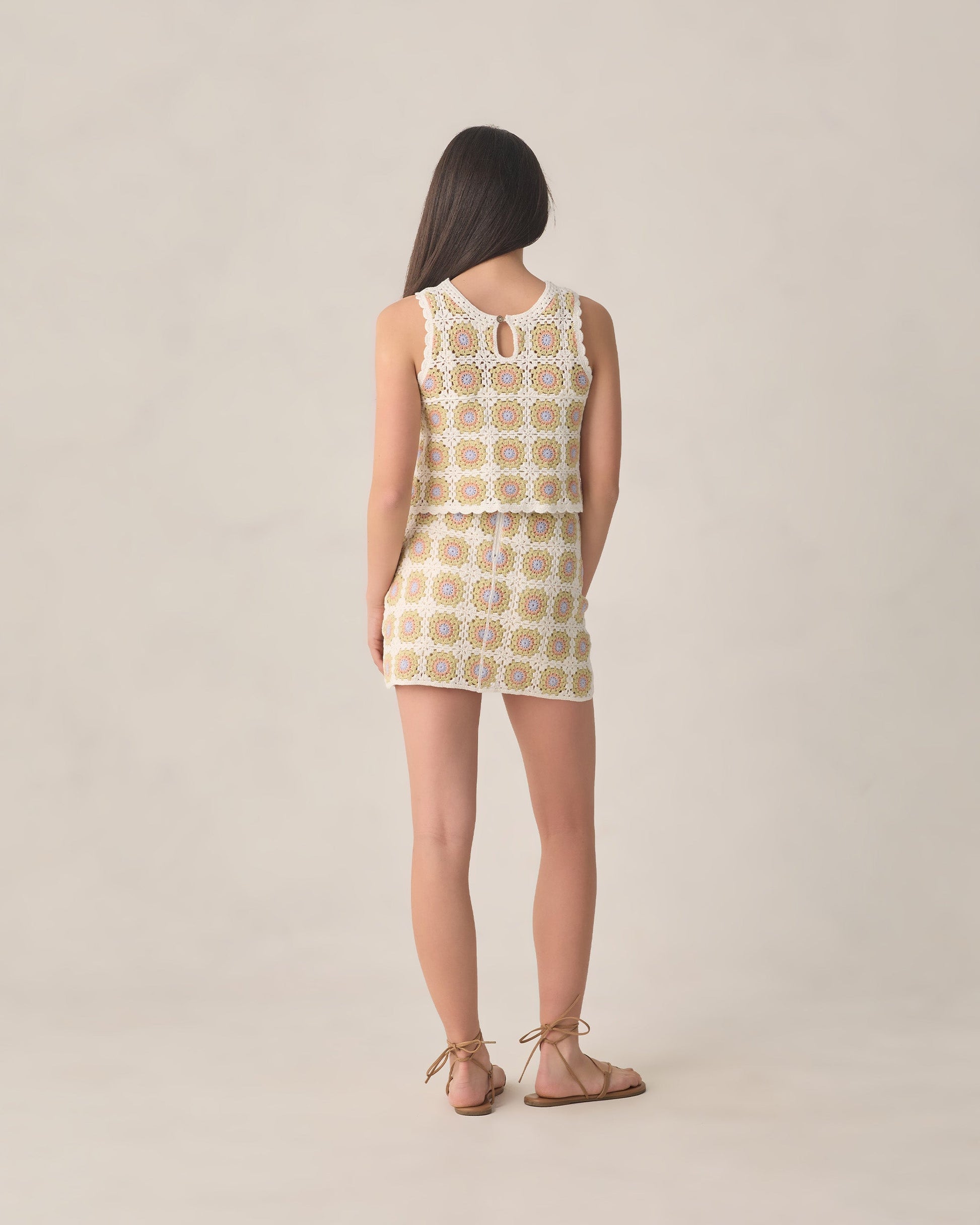 A woman faces away, wearing the Rylee & Cru Teen Girls' Crochet Tank Set in citron daisy check geometric pattern with brown sandals, posed against a neutral backdrop.
