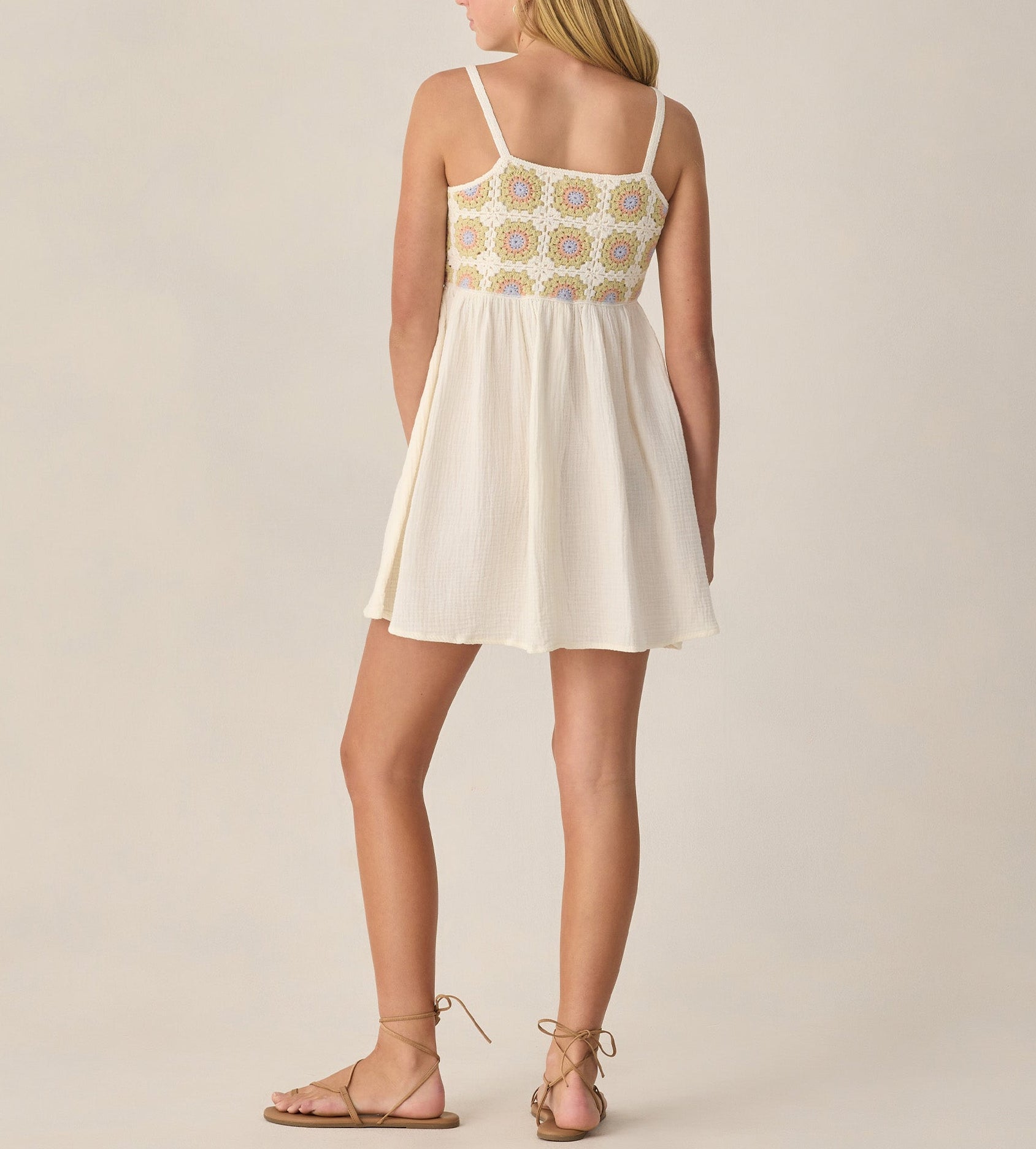 A teen girl wears the Rylee & Cru Crochet Sundress, featuring a patterned bodice, and flat sandals as she stands with her back to the camera against a neutral background.