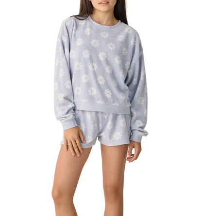A teen girl models the Rylee & Cru Karli Set—a light purple terry cloth sweatshirt and matching shorts with white daisy floral print—against a white background, creating a perfect summer outfit.