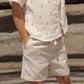 A child stands hands-in-pockets, wearing a cream short-sleeve polka dot shirt and matching Rylee & Cru Baby Boys' Perry Shorts with an elastic waistband, creating a vintage look against a rocky backdrop.