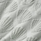 Close-up of light grey terry fabric with raised seashells, highlighting the texture—ideal for crafting the Rylee & Cru Baby Girls' Cinch Playsuit, a breezy summer outfit.