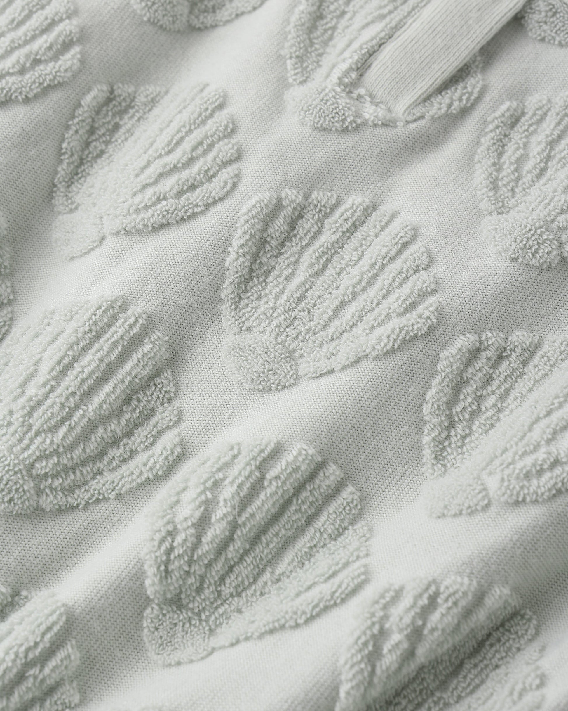 Close-up of light grey terry fabric with raised seashells, highlighting the texture—ideal for crafting the Rylee & Cru Baby Girls' Cinch Playsuit, a breezy summer outfit.