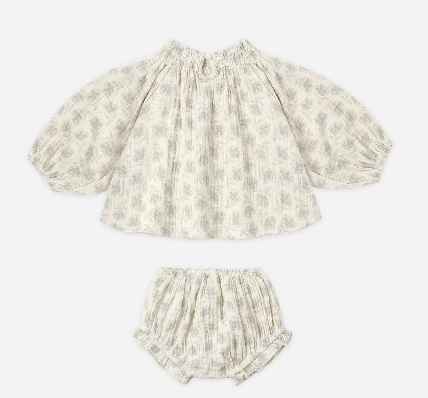 The Baby Girls’ Quincy Set by Rylee & Cru includes a long-sleeve top and coordinating bloomer made from lightweight fabric, showcasing a delightful gray leaf print on a crisp white background.