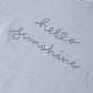 The Rylee & Cru Girls' Cropped Cinch Tee features a light blue color, cinched fit, and "hello sunshine" embroidered in gray cursive for a relaxed, cheerful look.