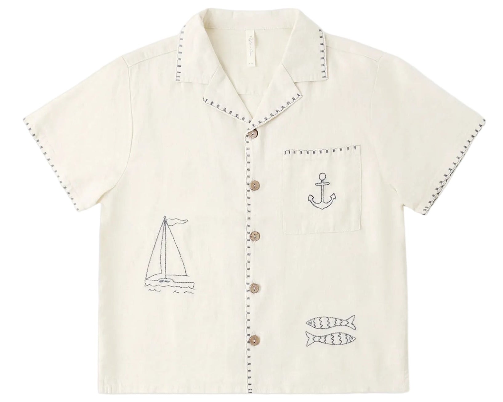 The Rylee & Cru Boys' Lapel Collar Shirt is a cream short-sleeve button-up with stitched sailboat, anchor, and fish designs on the front.