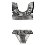 The Rylee & Cru Girls' Margot Bikini features a charming two-piece design in black and white gingham, with a ruffled collar on the top and a matching ruffled waistband on the bottom. This stylish swimsuit also provides UPF 50+ protection, making it perfect for sunny days by the water.