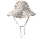 The Girls' Floppy Swim Hat by Rylee & Cru features a wide brim, chin straps, and a floral print in orange, blue, and green on white. It offers UPF 50+ sun protection for stylish outdoor safety.