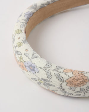Close-up of the Rylee & Cru Girls' Padded Headband, featuring a pastel bloom pattern with orange, blue, and yellow flowers on a white background—an ideal summer accessory.