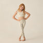 A young girl with long red hair stands barefoot, wearing a Rylee & Cru Girls' Swift Sports Top and matching leggings with a floral print, posing against a plain light background.