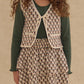 A young girl stands against a plain background in a green ribbed top, floral-patterned vest, and the Girls' Rose Mini Skirt by Rylee & Cru, which features scalloped tiers.