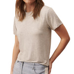 Woman wearing a gray short-sleeved TWP His Tee made from the softest jersey fabric and light blue jeans.