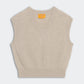 The Rib Vest by Guest in Residence is a beige ribbed knit cashmere sleeveless sweater with a V-neck and a yellow GIR Branding label inside the collar, displayed flat on a light background.