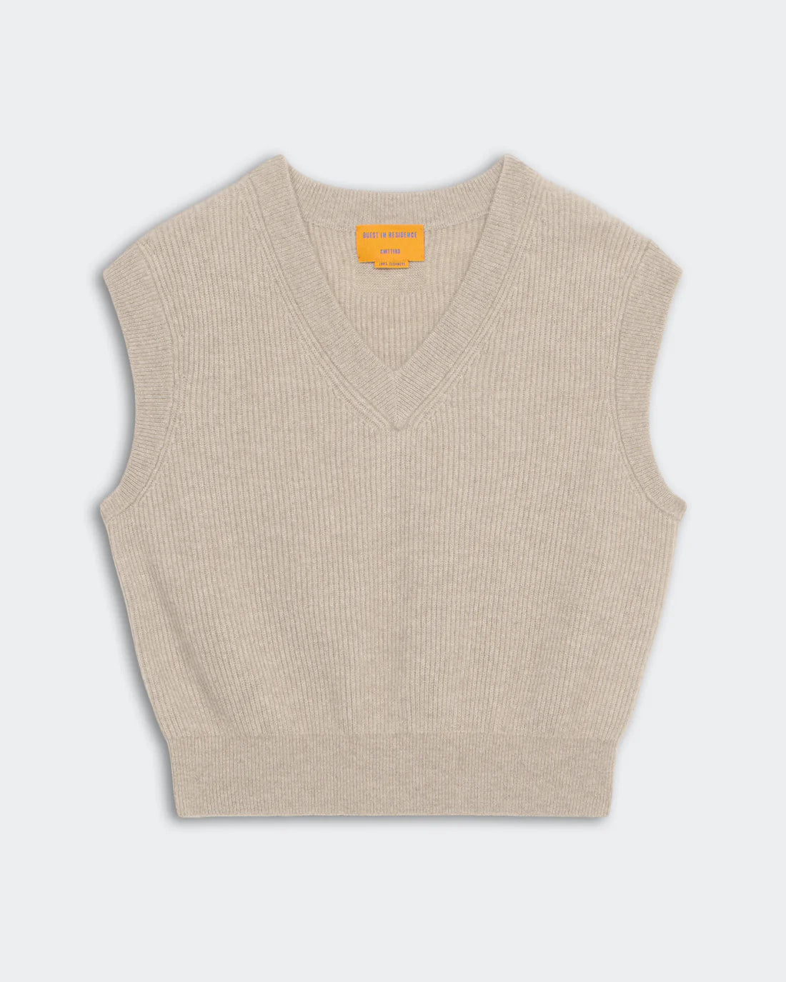 The Rib Vest by Guest in Residence is a beige ribbed knit cashmere sleeveless sweater with a V-neck and a yellow GIR Branding label inside the collar, displayed flat on a light background.