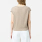 A person with long hair is shown from the back wearing the beige Rib Vest by Guest in Residence with white pants, against a plain background, highlighting its soft cashmere texture.