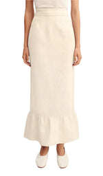 A person wears the POSSE Matilda Column Skirt—a premium linen, high-waisted skirt with a ruffled hem—paired with a white top and white shoes.