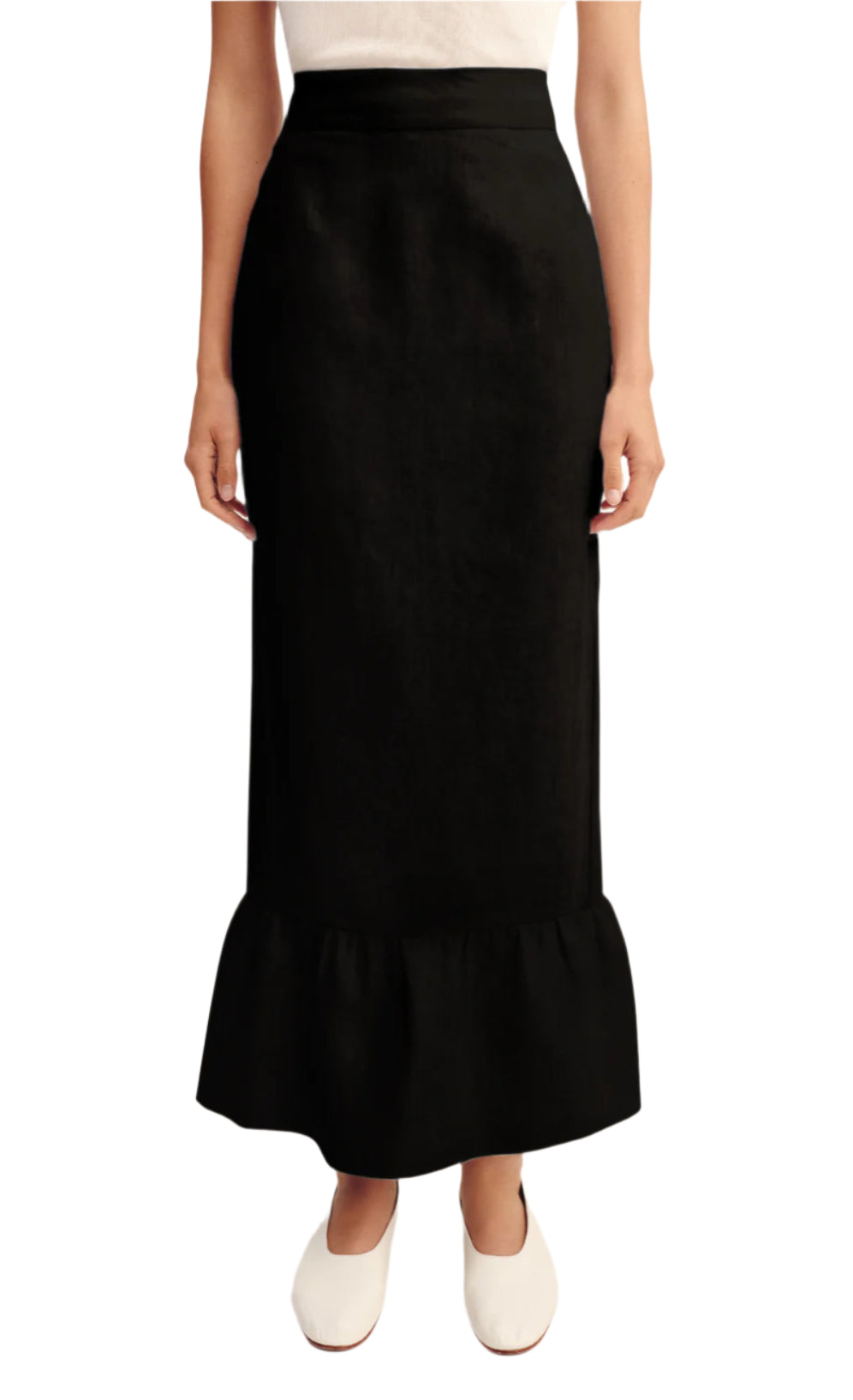 A person wears the POSSE Matilda Column Skirt, featuring a high-rise waist and ruffled hem, paired with a white sleeveless top and white slip-on shoes.