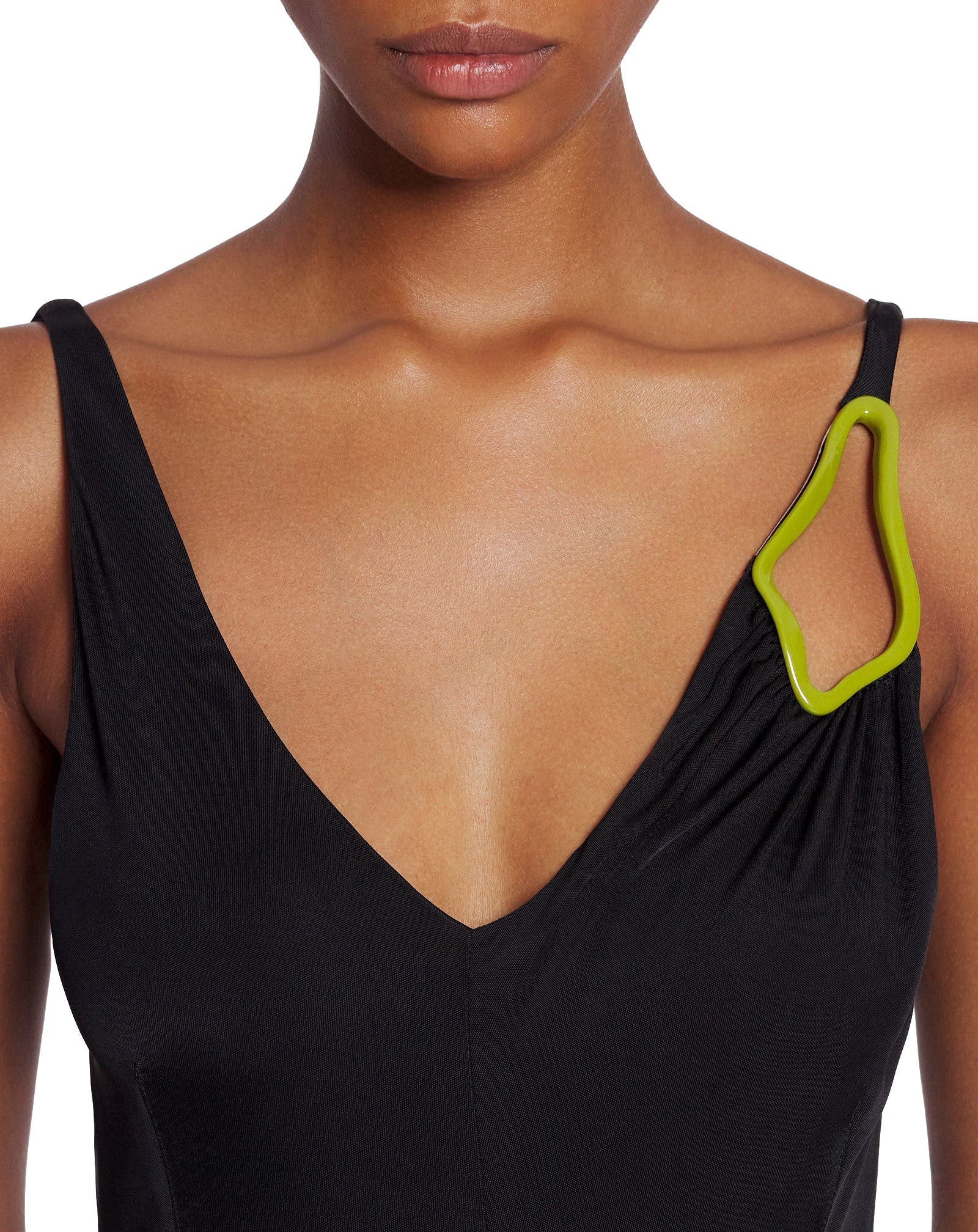 Close-up of a woman wearing a black v-neck Lanvin Sleeveless A-Line Midi Dress, with a neon green clip attached to the strap.