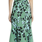 A person showcases Lanvin woman's flair in the Lanvin Jacquard Midi Dress, featuring a green hue with black and blue floral patterns and an asymmetrical hemline, visible from the back.