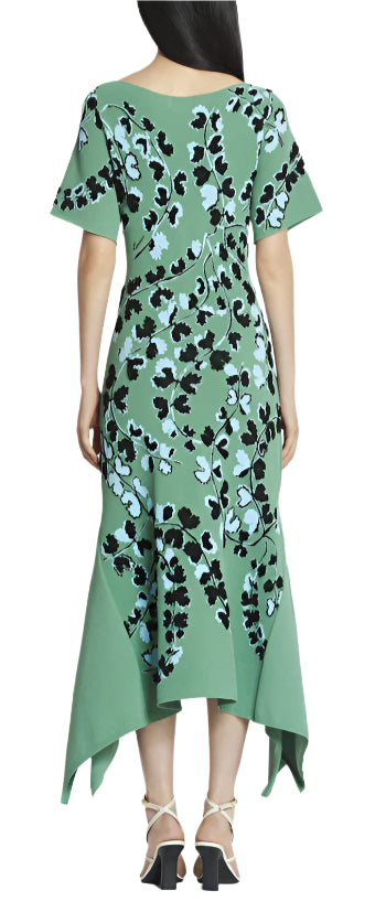 A person showcases Lanvin woman's flair in the Lanvin Jacquard Midi Dress, featuring a green hue with black and blue floral patterns and an asymmetrical hemline, visible from the back.