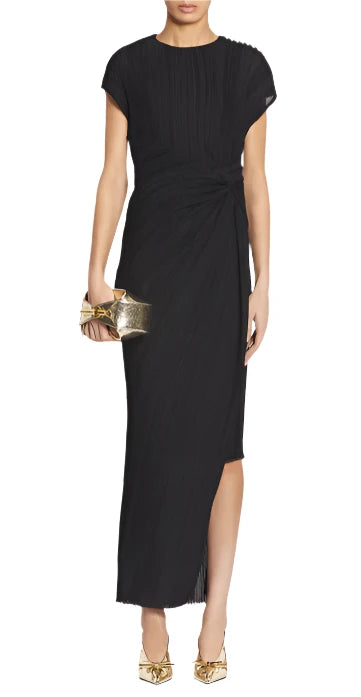 A person wearing a sophisticated Lanvin Asymmetrical Long Pleated Dress in black, carrying a gold clutch, and complemented by gold high heels.