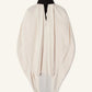 The Lanvin Knotted High Neck Cape is a cream-colored, haute couture, loose-fitting cape with a black stand collar, grosgrain bow detail, and draped sleeves, displayed against a plain light background.