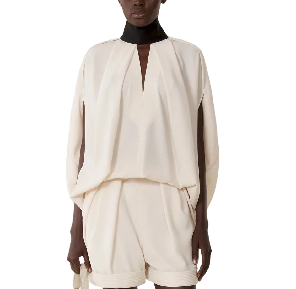 A model showcases the Lanvin Knotted High Neck Cape, standing against a white backdrop and exuding subtle Haute Couture elegance.
