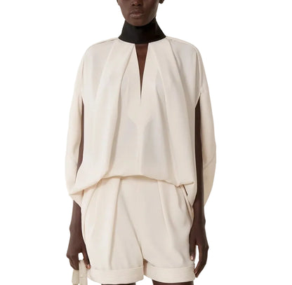 A model showcases the Lanvin Knotted High Neck Cape, standing against a white backdrop and exuding subtle Haute Couture elegance.