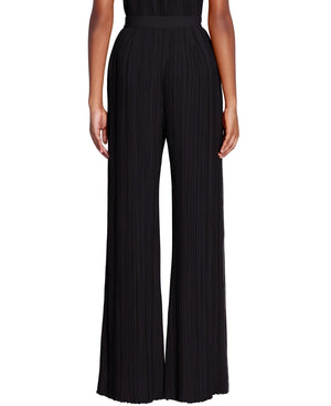 Front view of a person wearing Lanvin Pleated Pants, high-waisted, wide-leg black pleated pants with vertical pleats, crafted from elegant crêpe de Chine.