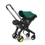 The Doona Car Seat and Stroller by Doona is a green and black infant car seat that easily converts into a travel system with an extended handle and four wheels, resembling a stroller.