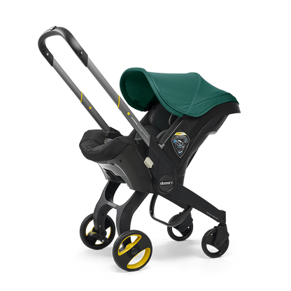 The Doona Car Seat and Stroller by Doona is a green and black infant car seat that easily converts into a travel system with an extended handle and four wheels, resembling a stroller.