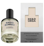 A 50ML bottle of "Radio Bombay" by D.S. & Durga rests stylishly beside its matching box. The clear bottle with a black cap releases sandalwood and musk notes, echoing vintage radio tunes. The box prominently features the brand's logo and text.