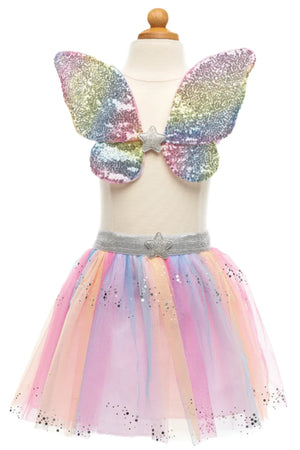 The Great Pretenders Rainbow Sequins Skirt, Wings & Wand set features a child's dress on a mannequin that dazzles with rainbow sequin wings and a pastel tulle skirt, embellished with star accents. The ensemble is complete with a star wand covered in sequins for an extra touch of magic.