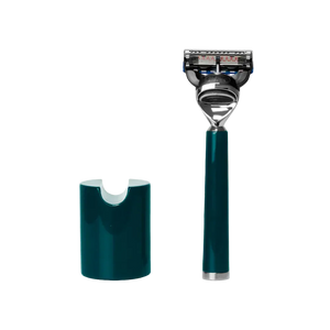 The Barberino's Ultimate 5 Blade Razor, featuring an ergonomic teal and silver handle, stands upright beside its matching teal holder against a white background.