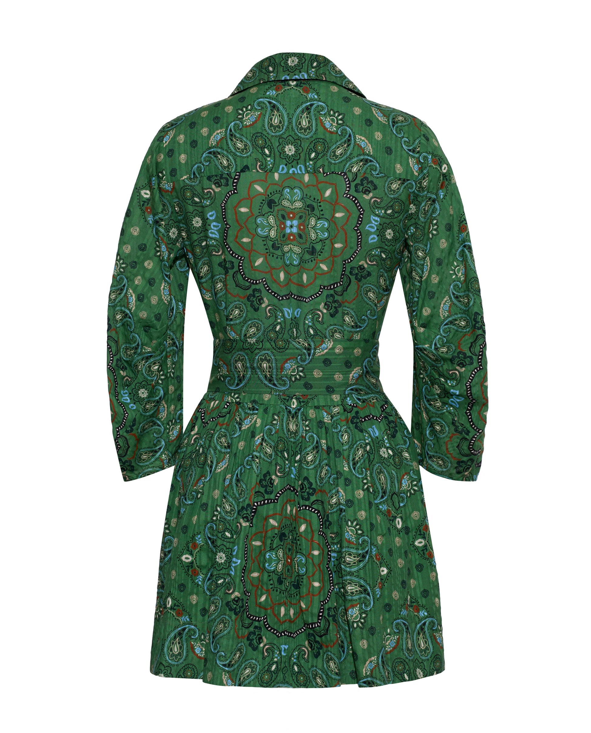 The Raya Mini Dress by Cara Cara showcases a green long-sleeve silhouette adorned with a mandala and paisley print, seen from the back. It features a fitted waist with an elegant sash accent and a flared skirt.