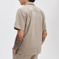 A person is seen from the back wearing the Rag & Bone Resort Denim Shirt with matching pants, hands in pockets and forearm tattoos visible—an effortless look for resort style.