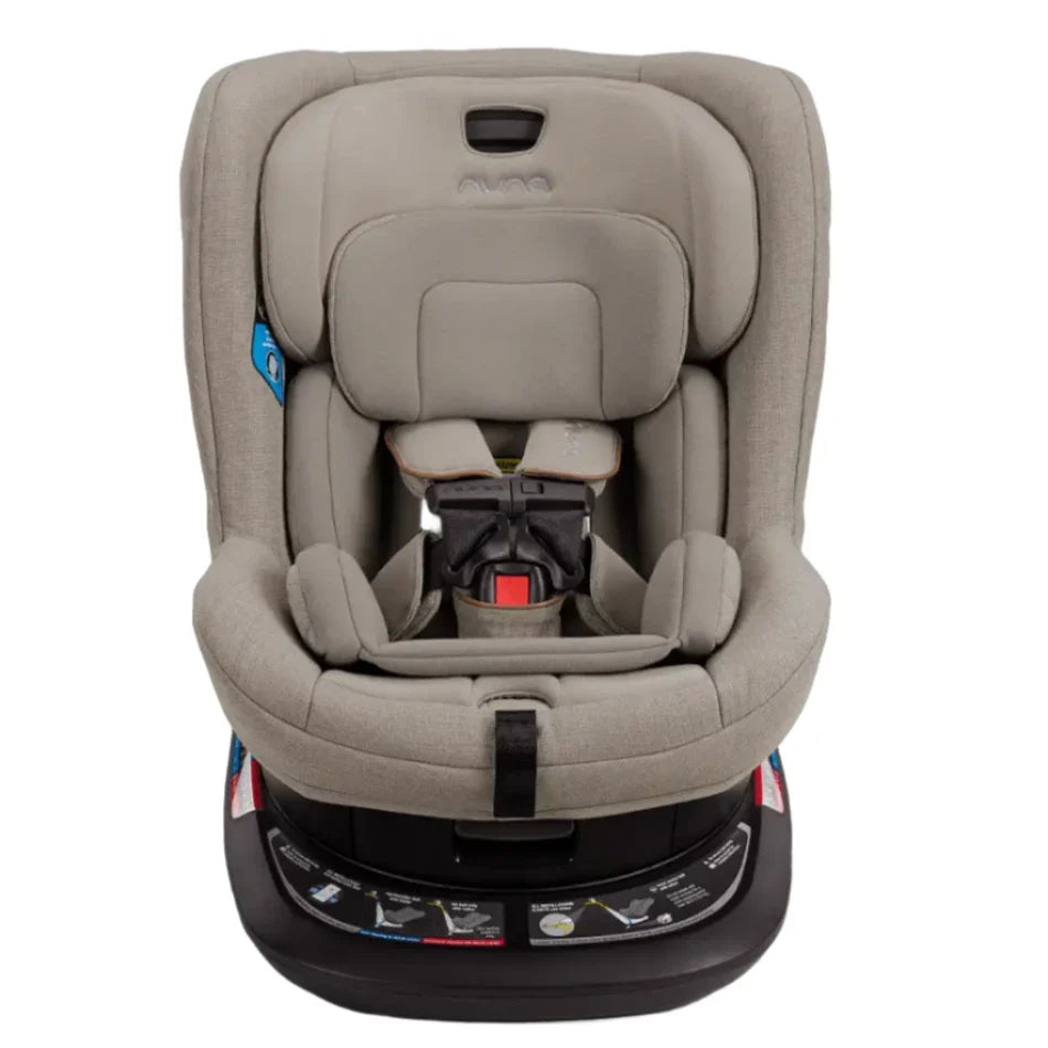 The Nuna Revv Carseat by Nuna is a gray child car seat featuring a five-point harness, adjustable headrest, and side impact protection, all mounted on a black base.