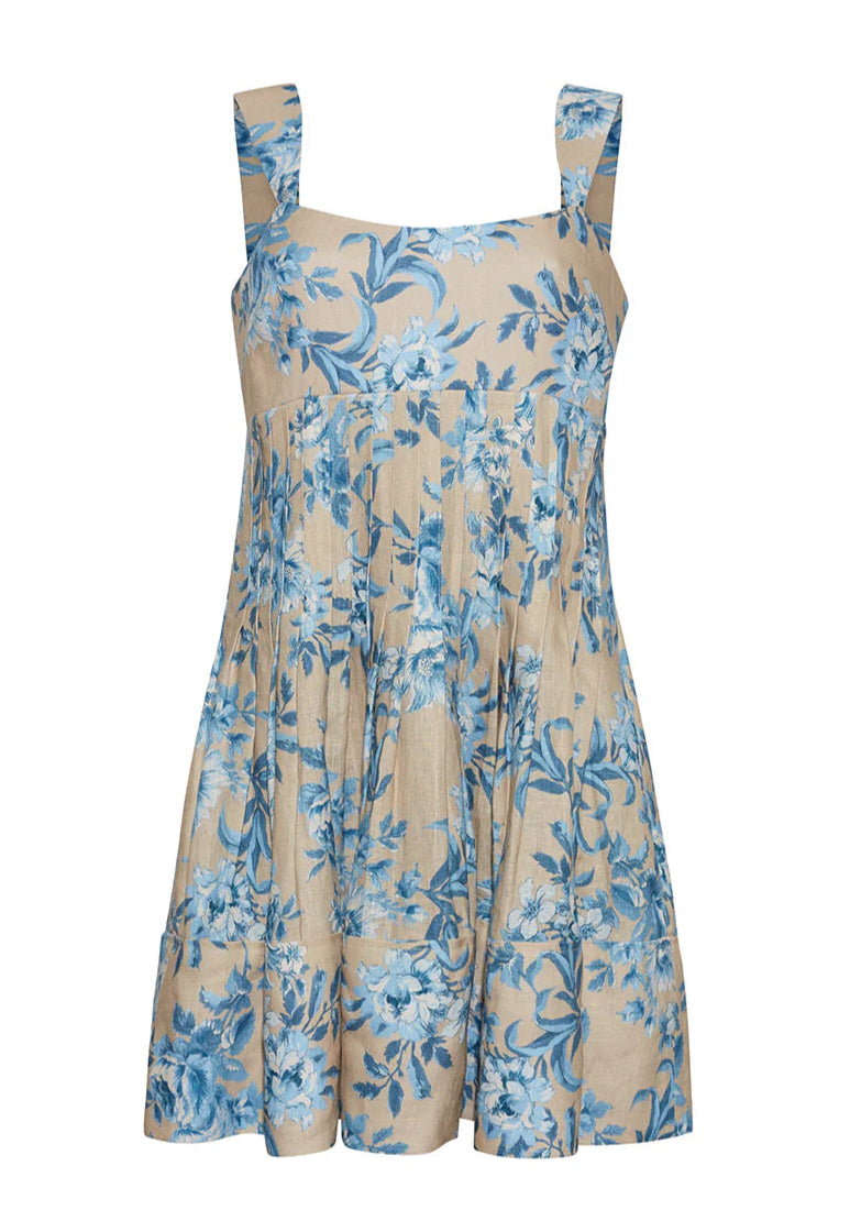 The Cara Cara Ria Dress is a sleeveless beige dress with wide straps, blue floral print, pintucked details, a loose gathered skirt, and a square neckline for a picture-perfect look.