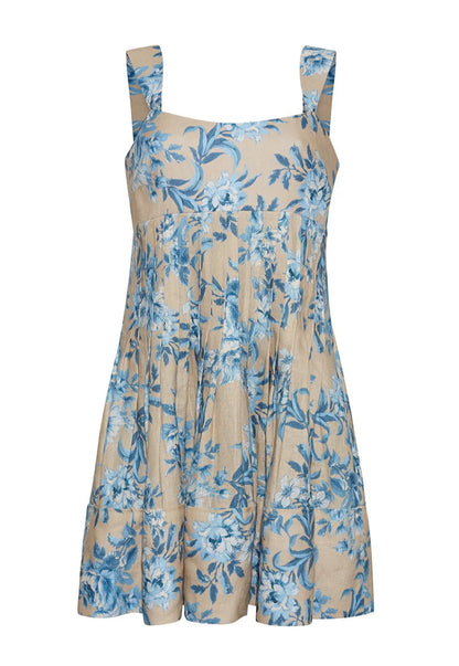 The Cara Cara Ria Dress is a sleeveless beige dress with wide straps, blue floral print, pintucked details, a loose gathered skirt, and a square neckline for a picture-perfect look.