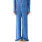 A person in Guest in Residence's Rib Everywear Pant—loose-fitting, lightweight women's knit pants with a buttoned front—stands in sandals, making them perfect travel pants.