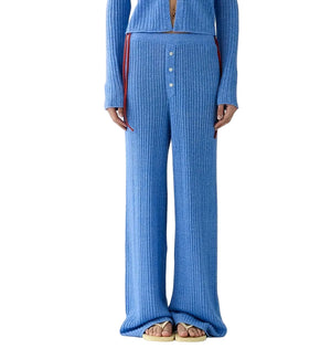A person in Guest in Residence's Rib Everywear Pant—loose-fitting, lightweight women's knit pants with a buttoned front—stands in sandals, making them perfect travel pants.