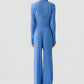 A person stands facing away in a matching blue ribbed knit long-sleeve top and Rib Everywear Pant by Guest in Residence, featuring wide legs, against a plain light background.